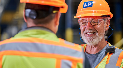 Man with beard and helmet smiling at another man