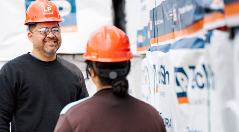 Man with helmet smiling at woman.