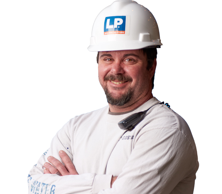 A smiling worker in a hard hat and with folded arms.